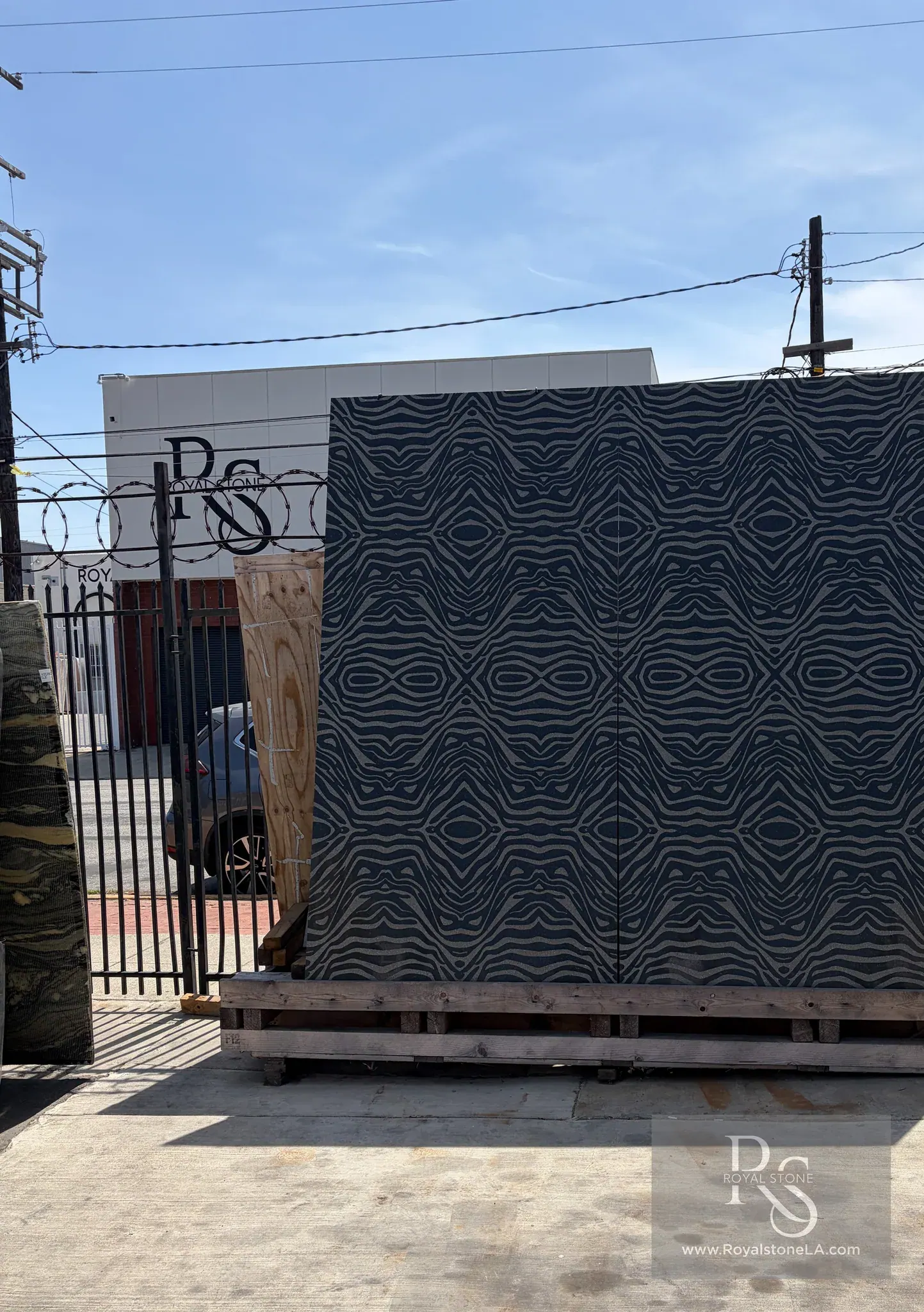Antolini Ebony Black granite — Bengal Black Zebra pattern from the Design (LUX) Natura Collection, deep black field with cream zebra-wave engraving, bookmatched pair at the Royal Stone yard