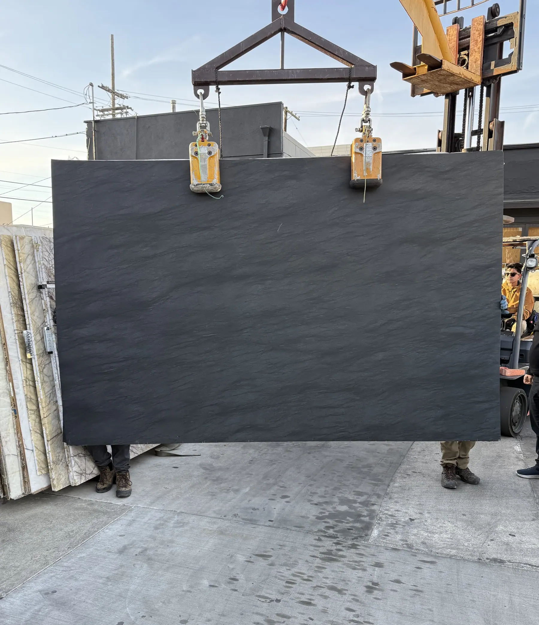 Antolini Bohemian Carbon Grey quartzite slab on the crane at Royal Stone, near-black field with a soft slate-like textured surface