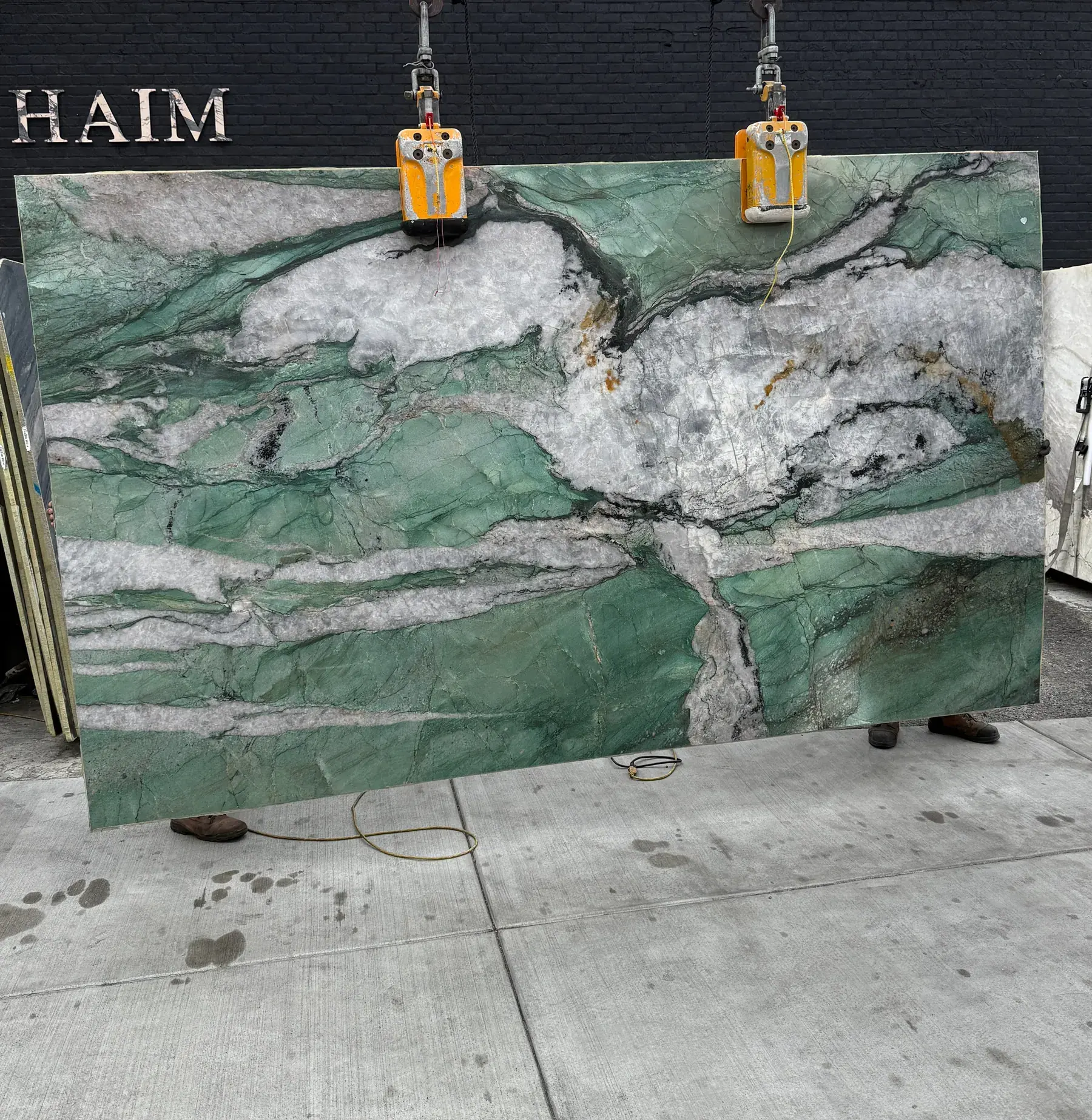 Antolini Cristallo Tiffany Jade Patagonia quartzite slab on the crane, jade-green field with crystalline white drifts, polished finish