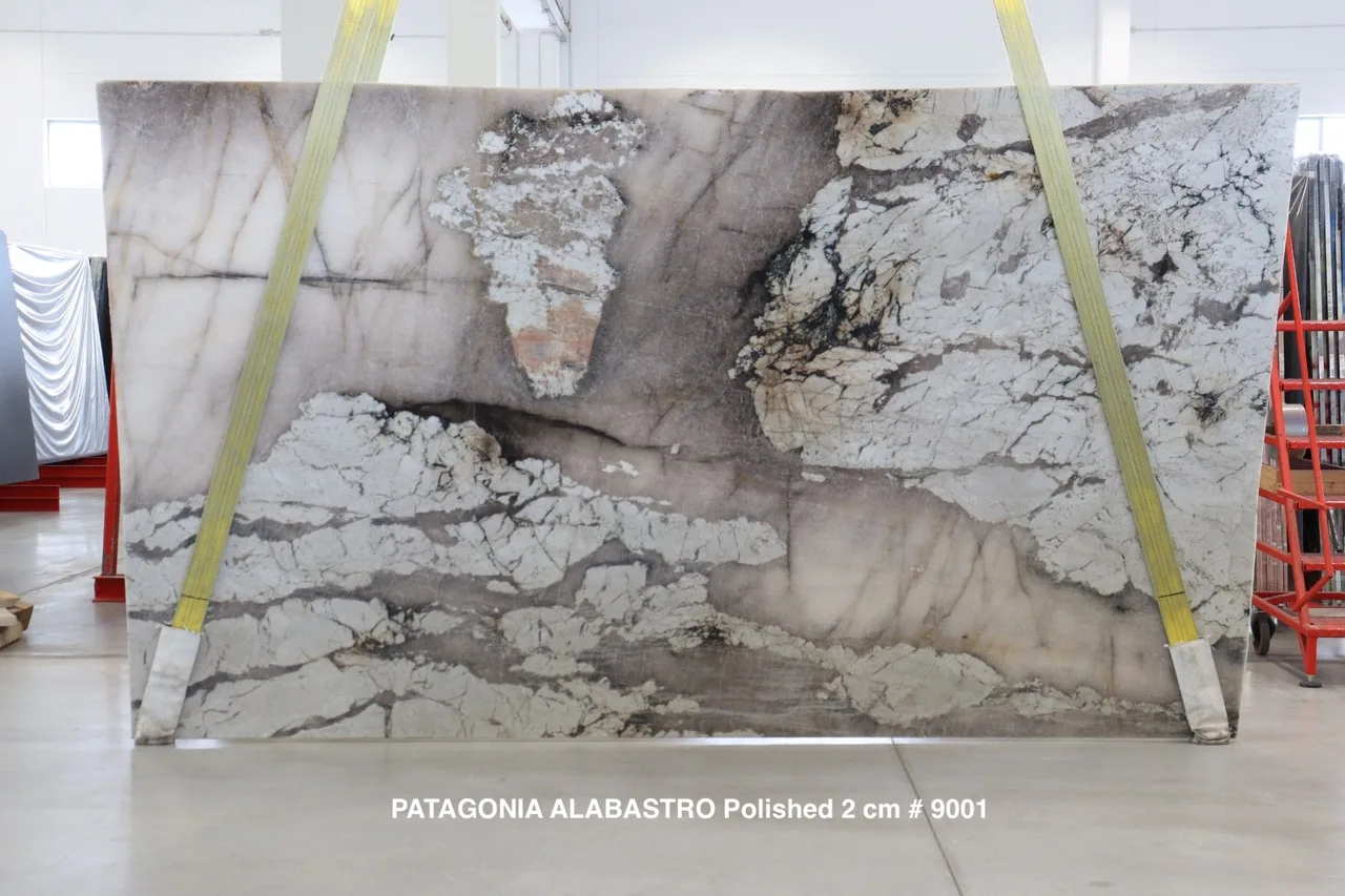 Antolini Patagonia Alabastro quartzite slab with translucent pink-grey field and dramatic white cloud formations, polished finish