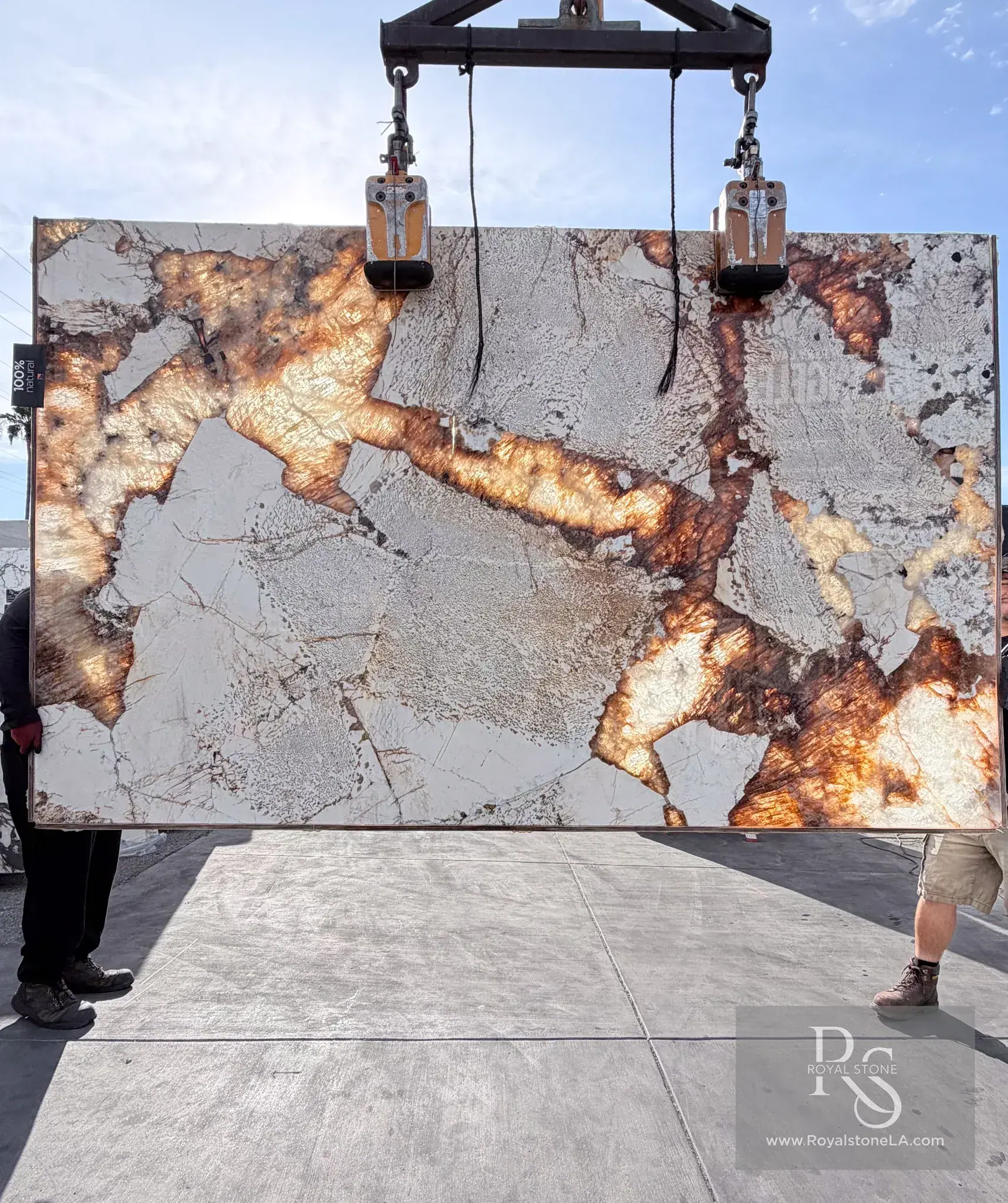 2cm Antolini Patagonia Original Unique AO683 polished quartzite slab backlit, the rust and amber veining lit up like cut citrine and molten gold while the ivory fragments hold quiet