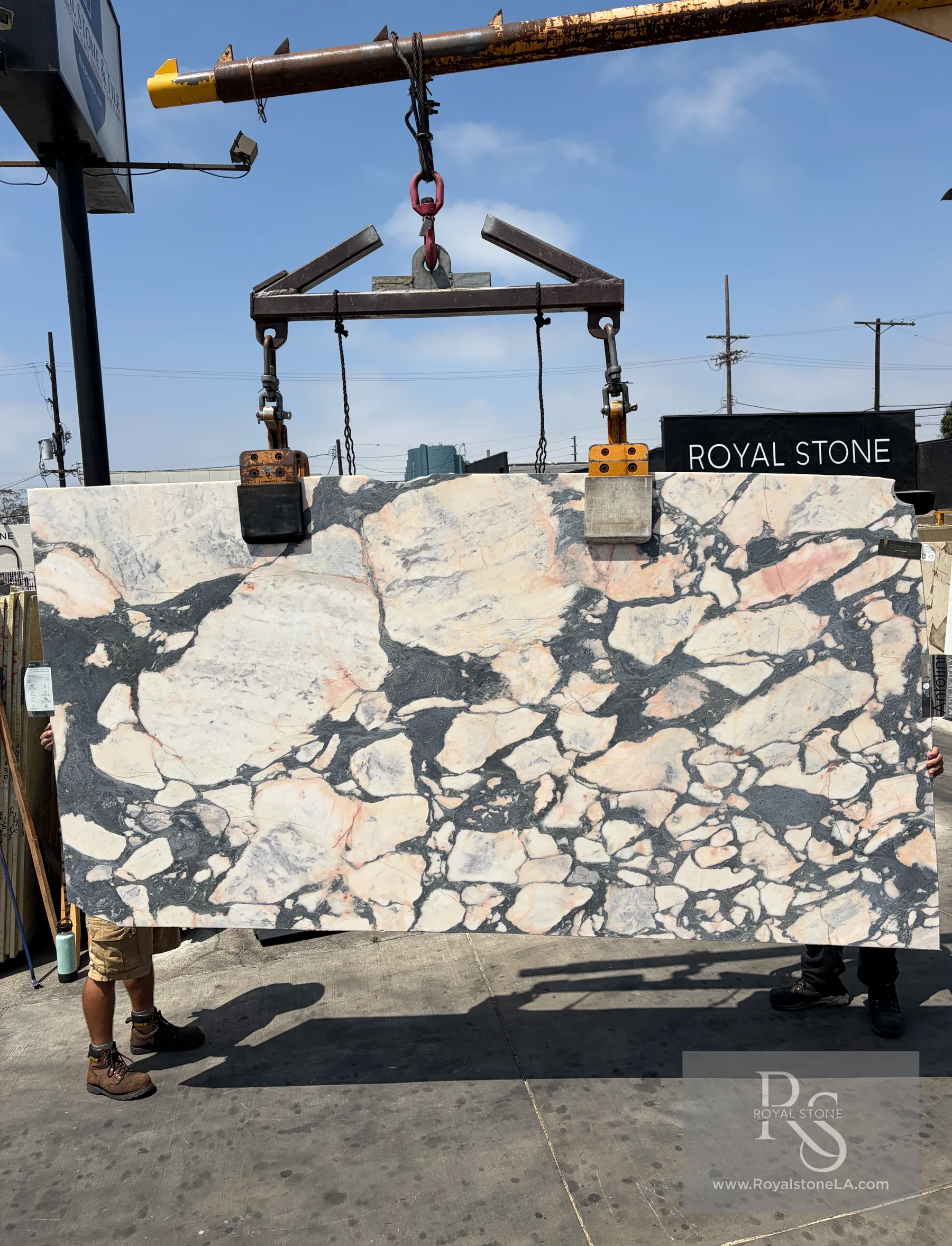 Antolini Viola Paonazzo Brecciato EG855 honed marble slab lifted on the crane at Royal Stone Los Angeles, white field with peach, salmon and rose fragments bound by storm-grey and black breccia veining