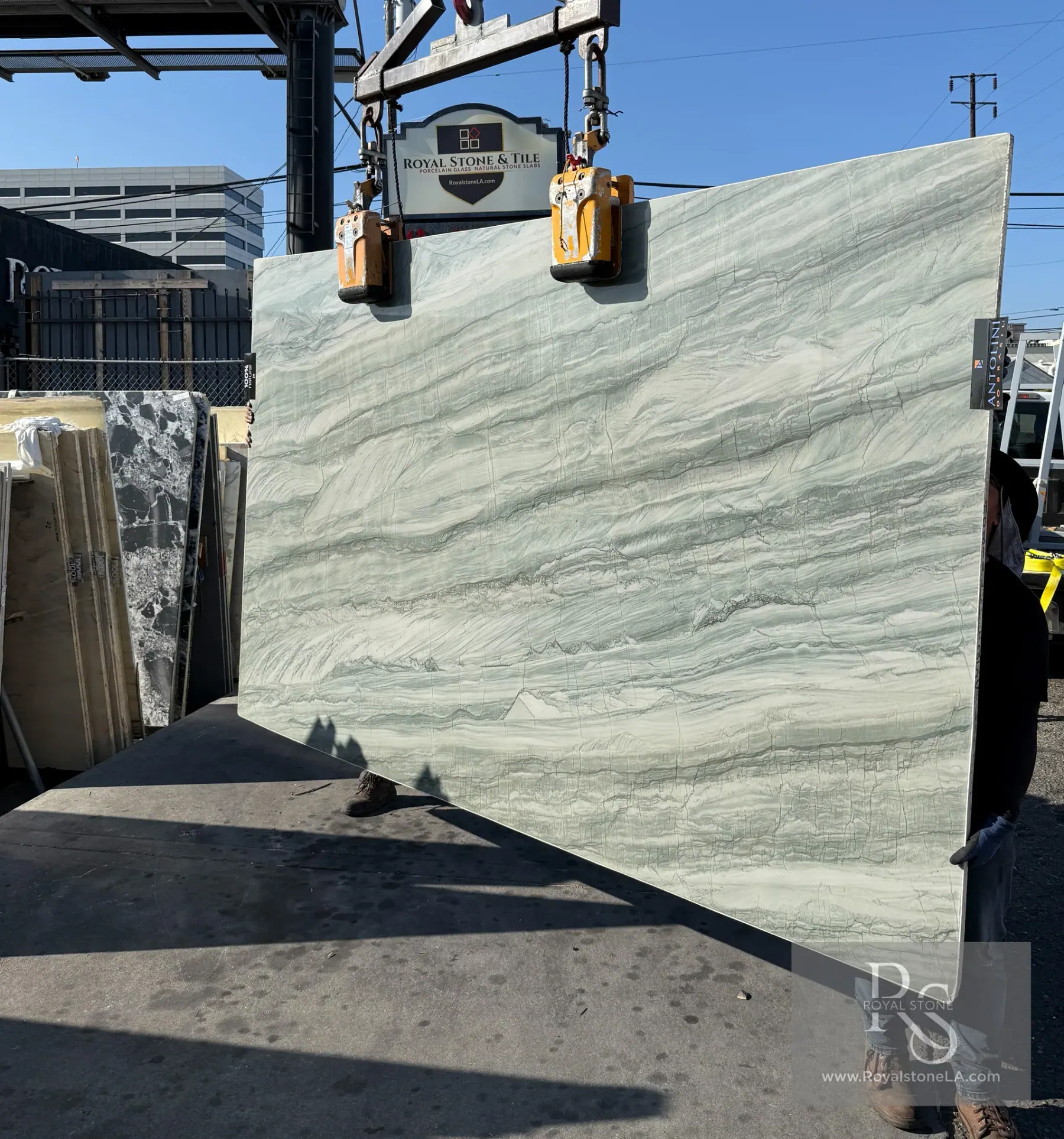 Antolini Aqua Green Ocean quartzite slab on the crane at Royal Stone, soft aqua-green field with horizontal banding, polished finish, 76 by 126 inches