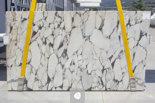 Calacatta Viola Super Extra marble slab with bold open brecciation, white clasts in a grey-and-gold network, polished finish