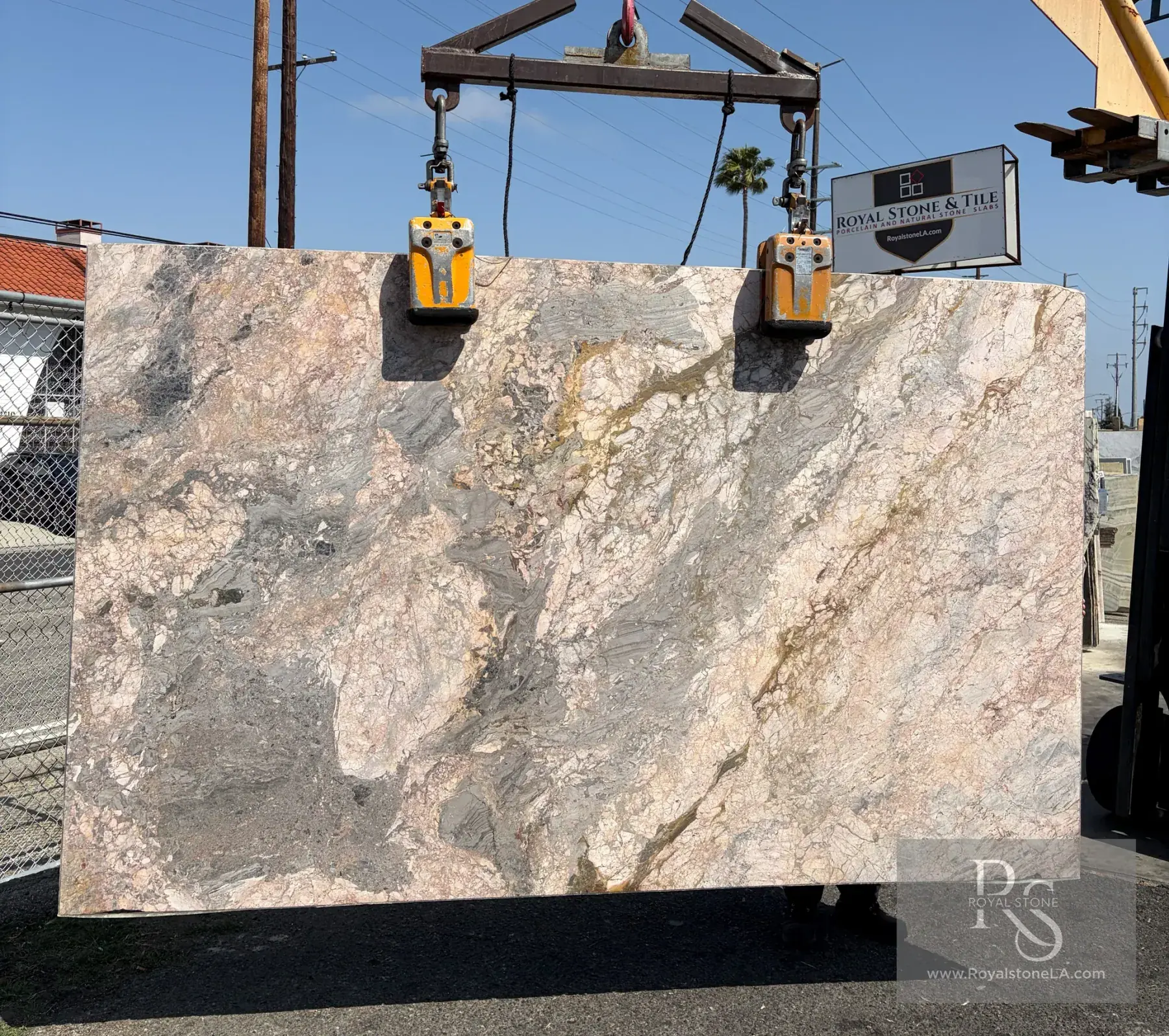Ceppo Viola Cosmo marble slab honed at 74 by 122 inches lifted on the crane at Royal Stone Los Angeles, pebbled conglomerate of pink, dove grey, and oxidized gold in a violet-grey matrix