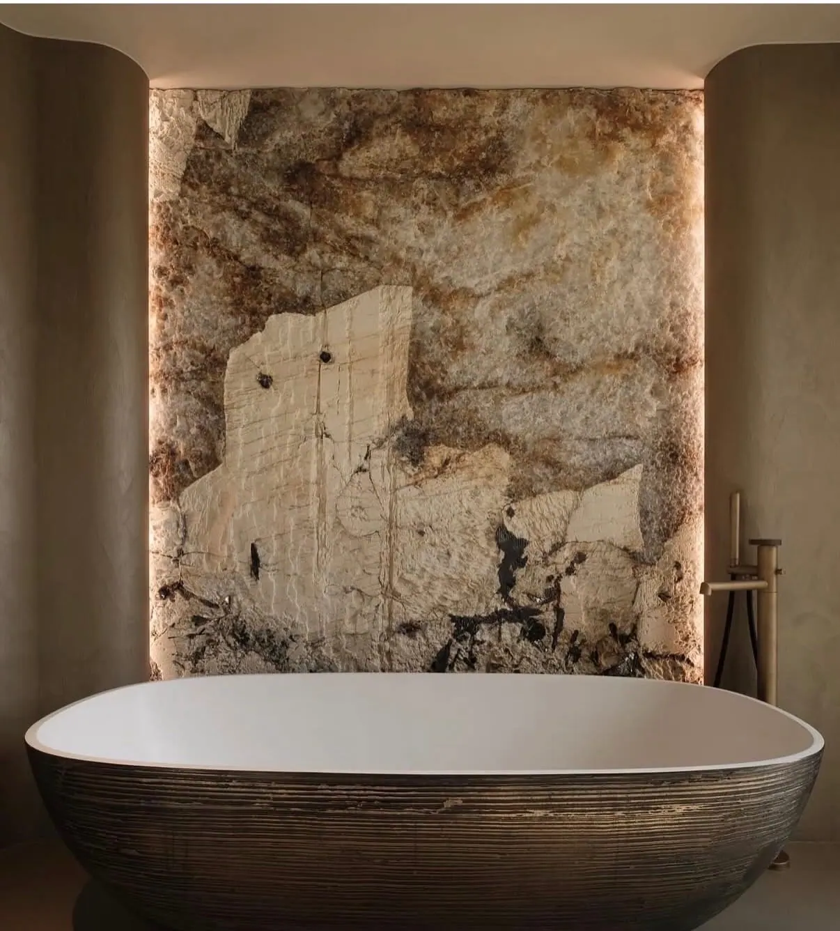 Patagonia Hard Rock finish quartzite installed as a backlit feature wall behind a freestanding bathtub