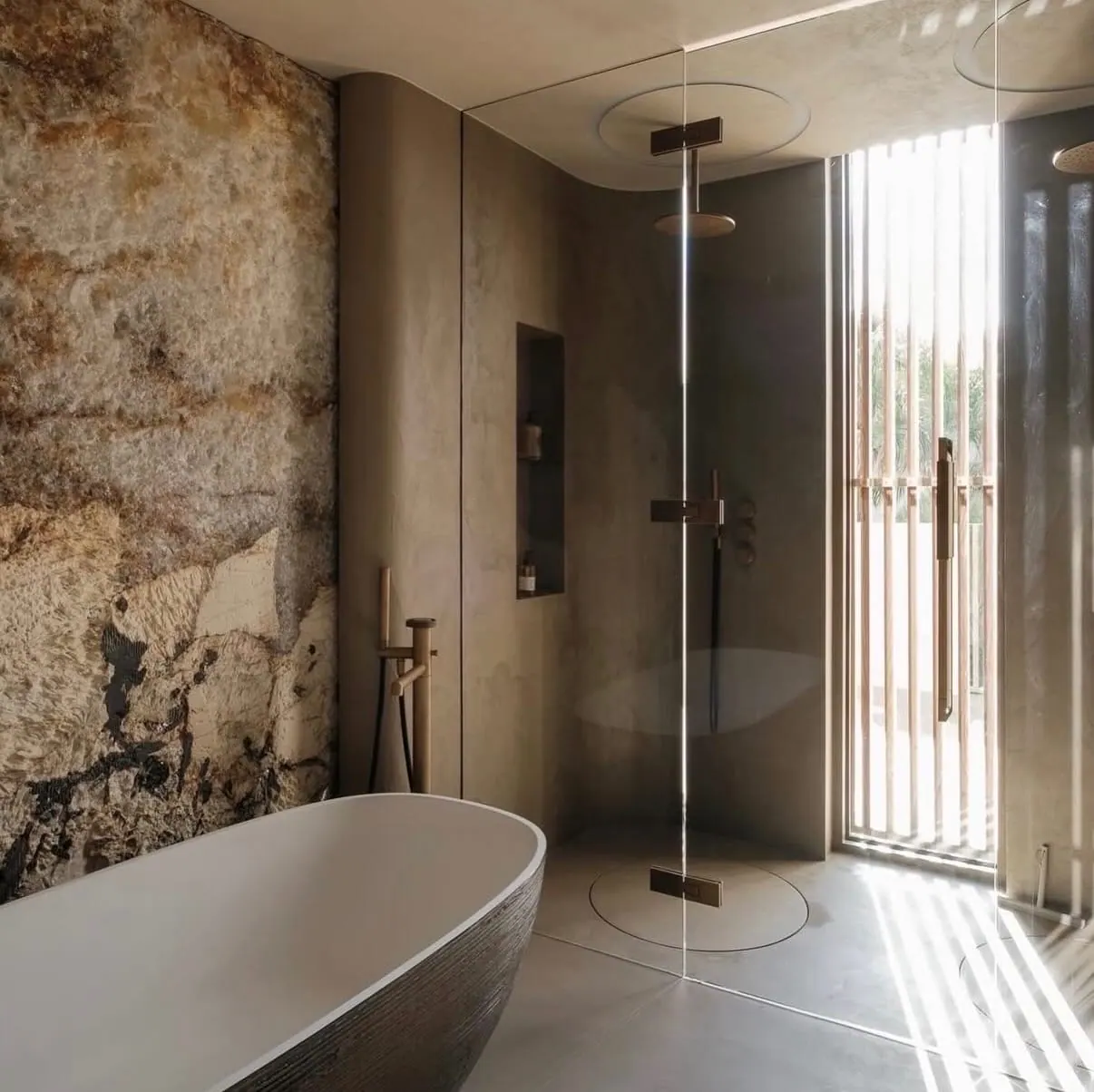 Patagonia Hard Rock finish quartzite feature wall in a stone-and-plaster bathroom with freestanding tub and walk-in shower